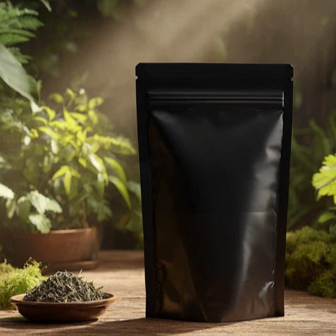 Black foil packaging on a wooden surface with plants in the background